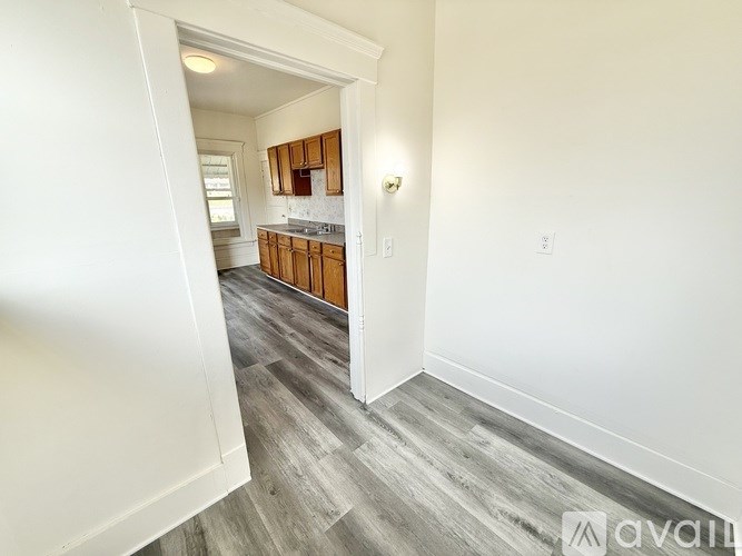 A room with a kitchen area in the background.