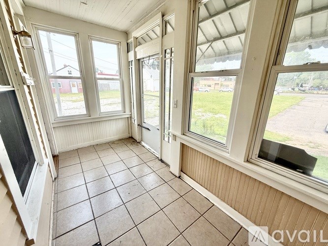 A room with a tiled floor and a large window overlooking a parking lot.