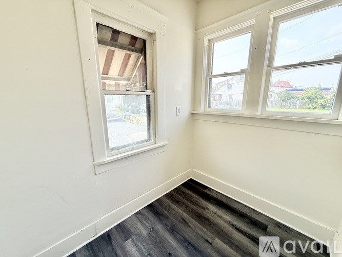 A room with a window and a wooden floor.