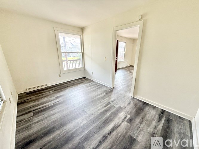 A room with wooden flooring and a window.