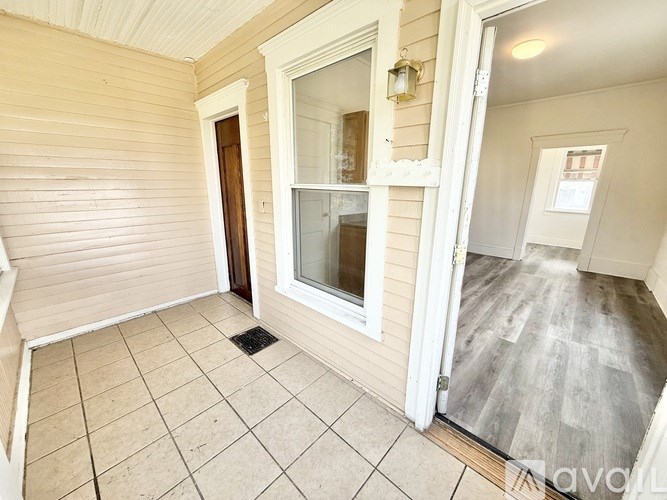 A room with a door, window, and a tiled floor.