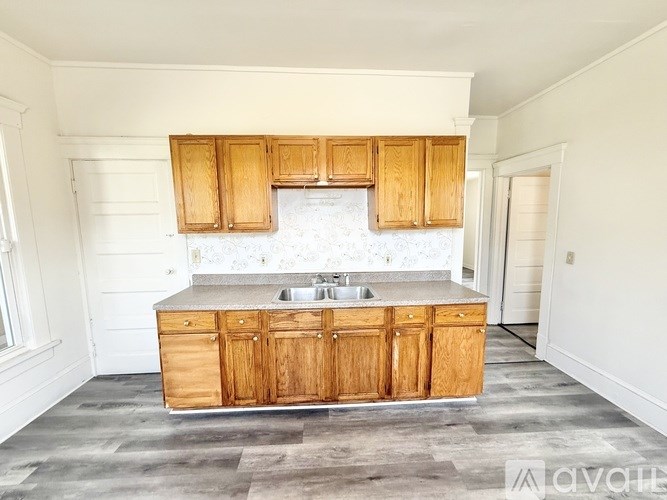 A kitchen with wooden cabinets and a marble countertop.