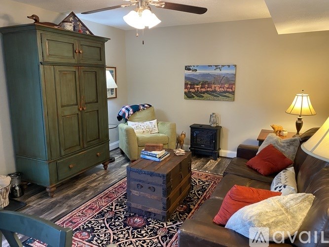 A living room with a green cabinet, a couch, a coffee table, and a painting on the wall.