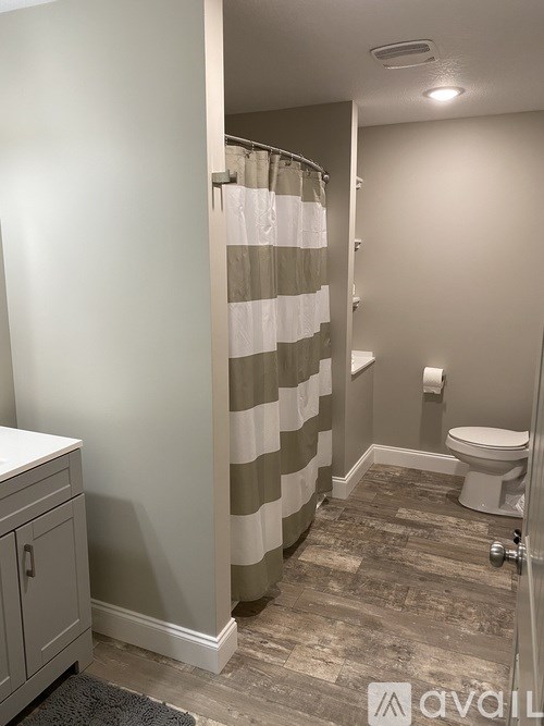 A bathroom with a toilet, a sink and a shower curtain.