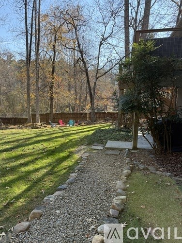 A backyard with a gravel path and a wooden fence.