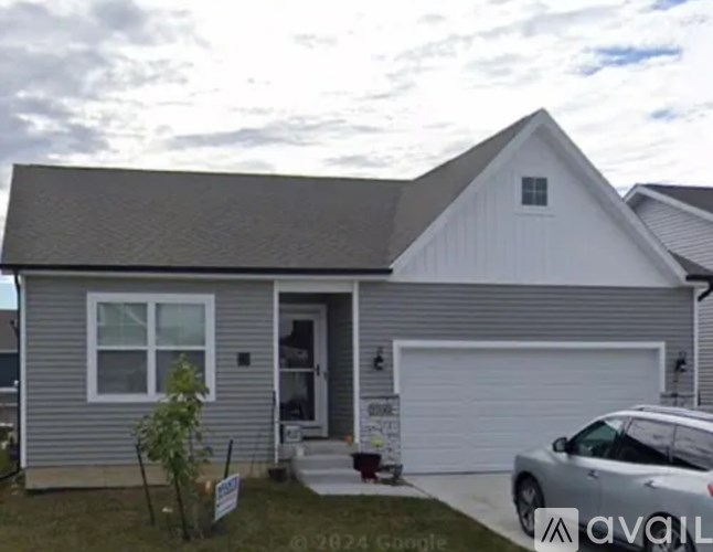 A house with a grey roof and a white garage door is for sale.