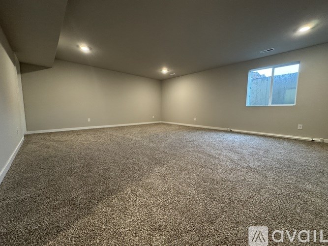 A room with carpeted floor and a window.