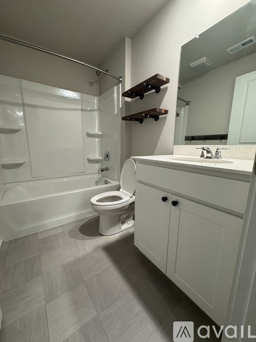 A white bathroom with a toilet, sink, and a walk-in shower.