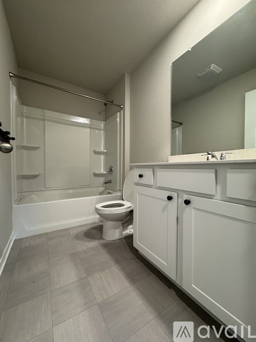 A bathroom with a toilet, sink, and shower.