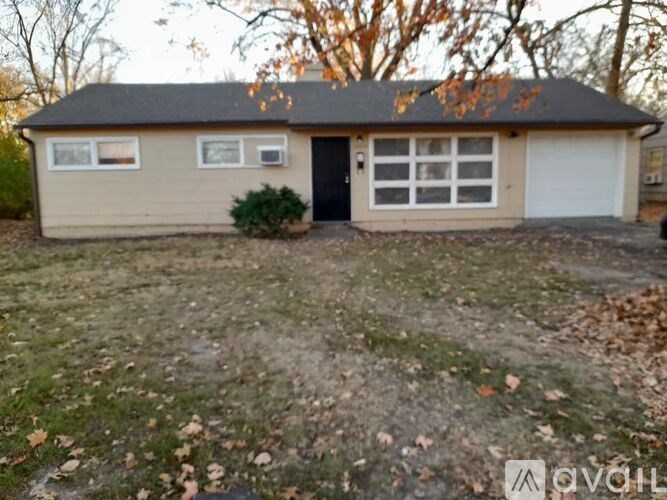 A detached house with a black door and white garage door.