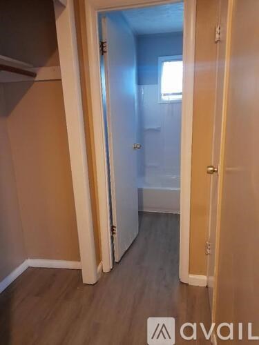 A hallway with a door on the right and a wall on the left.