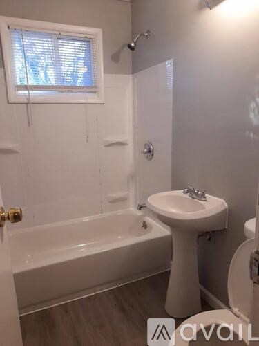 A white bathroom with a sink, toilet, and bathtub.