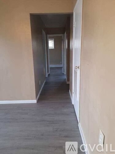 A long, narrow hallway with a door at the end.