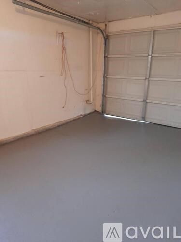 A garage with a white wall and a white door.