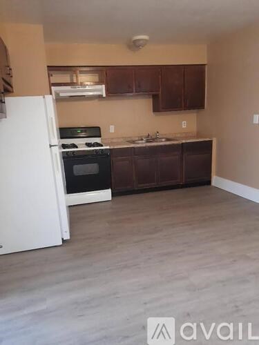 A kitchen with a white refrigerator and dark brown cabinets.