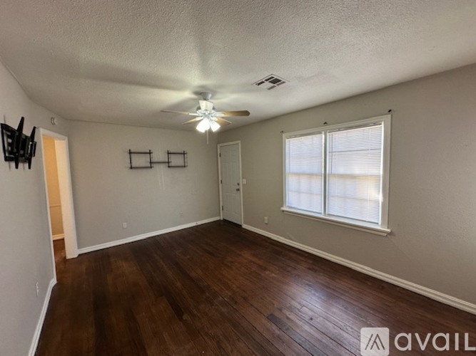 A room with a ceiling fan and wooden flooring.