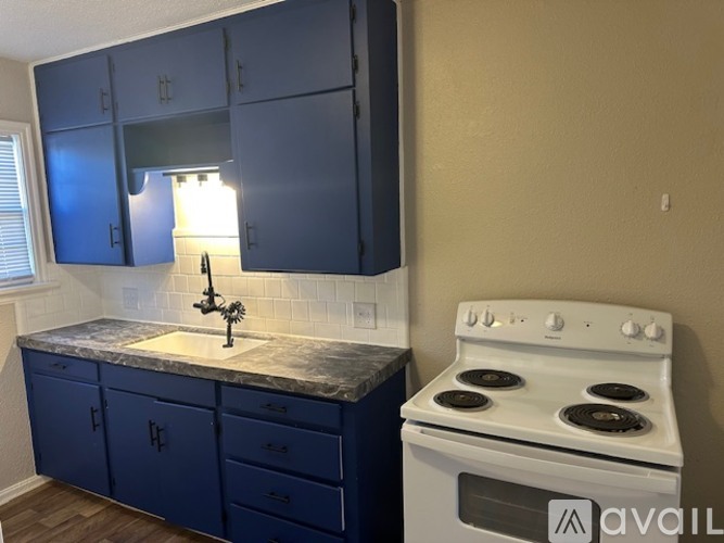 A kitchen with blue cabinets and a white stove.