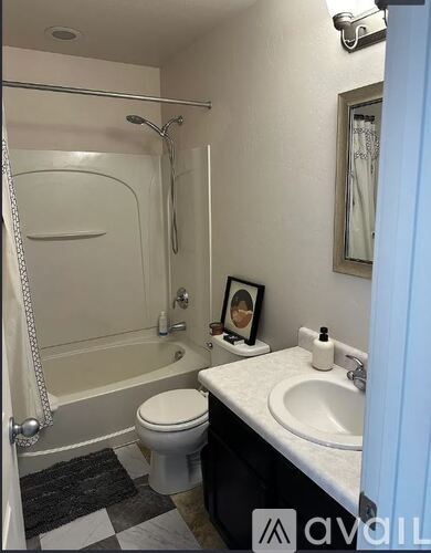 A bathroom with a toilet, sink, and shower.