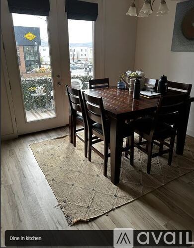 A dining room with a table set for two and a view of the street outside.