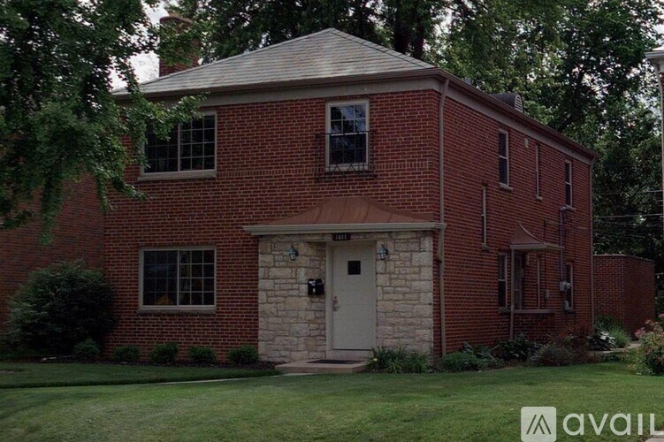 A red brick house with a white door and windows.