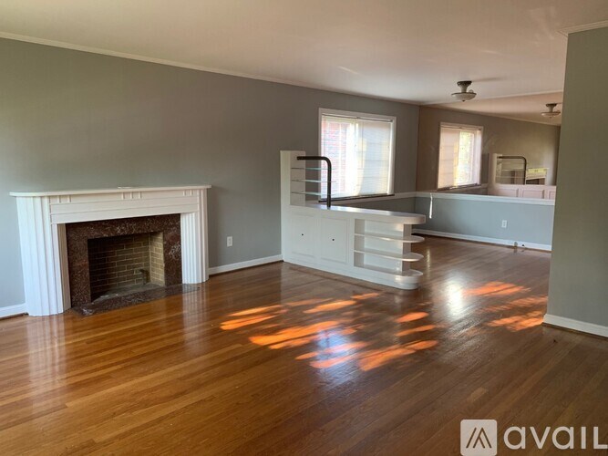 A living room with a fireplace and wood floors.