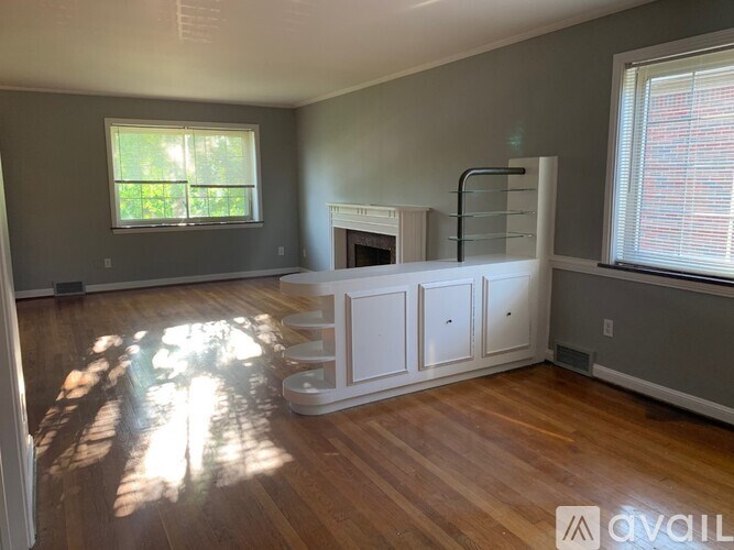 A living room with a fireplace and wood flooring.