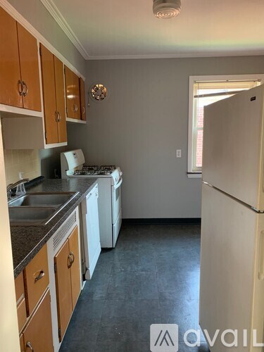 A kitchen with wooden cabinets and a white fridge.