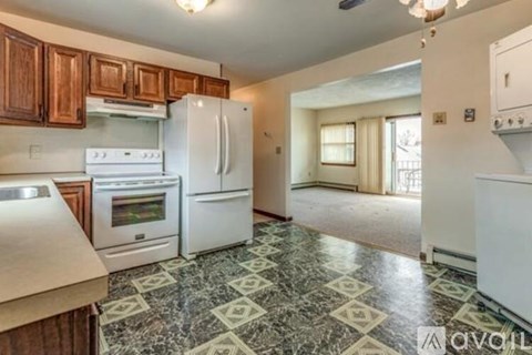 A kitchen with white appliances and a marble floor.