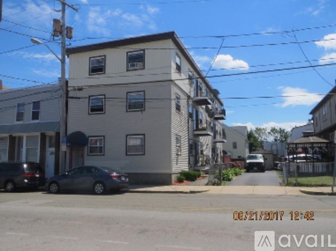 A grey building with a car parked in front.