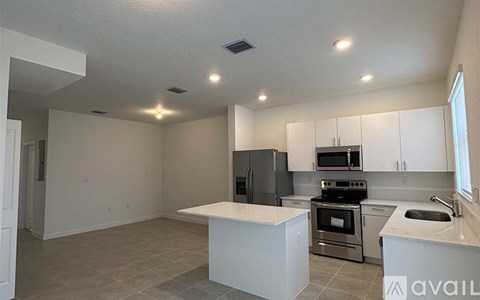 A kitchen with a white countertop and stainless steel appliances.