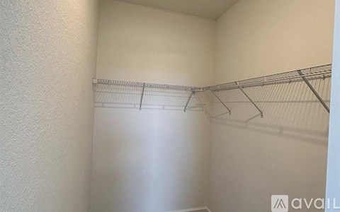 A white closet with a metal rod for hanging clothes.