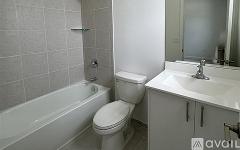 A white toilet sits next to a white sink in a bathroom.