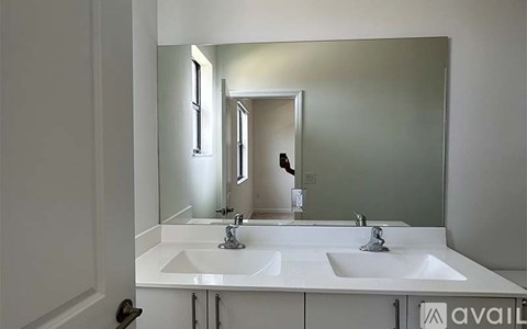 A bathroom with a white sink and mirror.