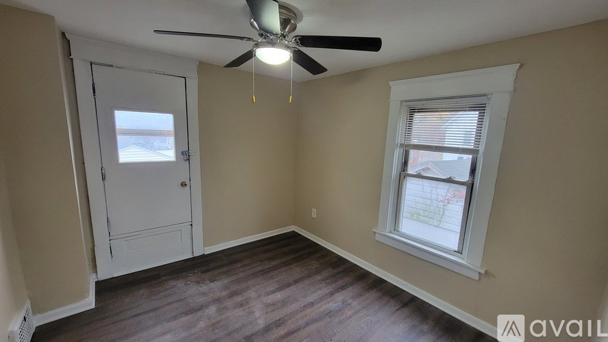 A room with a ceiling fan and a window.