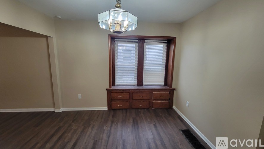 A room with wooden floors and a window with blinds.
