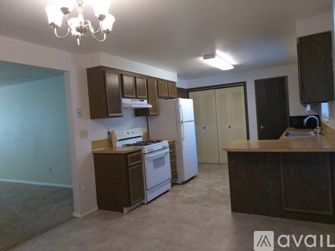 A kitchen with brown cabinets and a white stove top oven.
