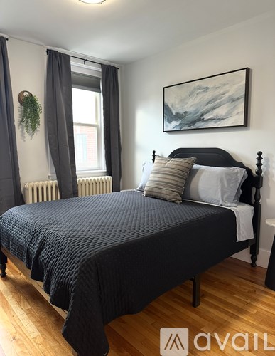 A bedroom with a large bed and a painting on the wall.