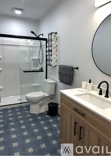 A bathroom with a toilet, sink, and shower.