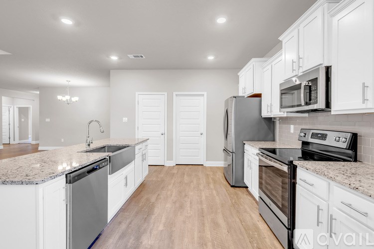 A kitchen with white cabinets and stainless steel appliances.