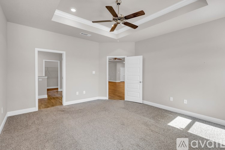 A spacious room with a ceiling fan and carpeted floor.