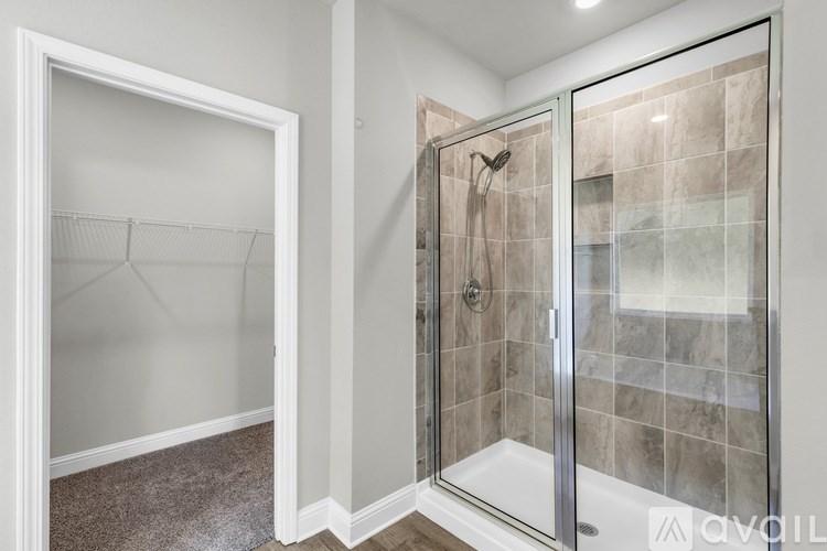 A bathroom with a walk-in shower and a white door.