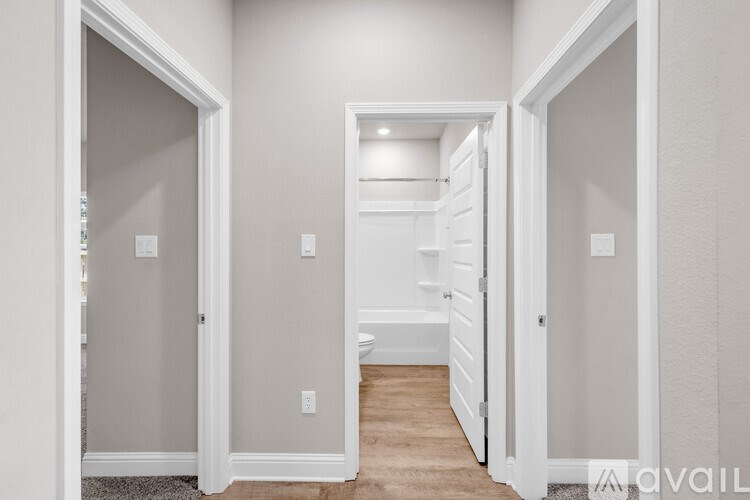 A hallway with white walls and a carpeted floor.