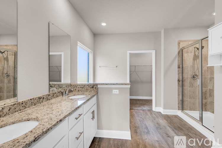 A bathroom with a marble countertop and a walk-in shower.