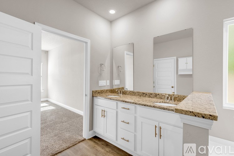 A bathroom with a granite countertop and white cabinets.