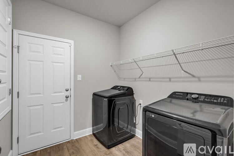 A kitchen area with two ovens and a door on the left.