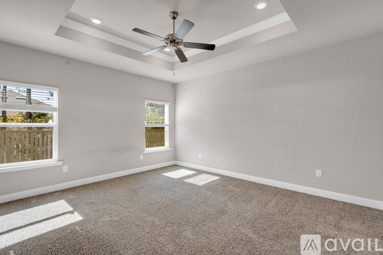 A room with a ceiling fan and carpeted floor.