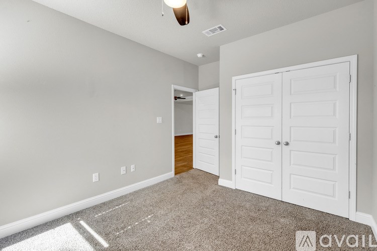 A room with a white door and a carpeted floor.