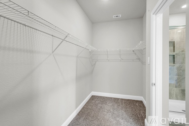 A walk-in closet with a carpeted floor and white walls.