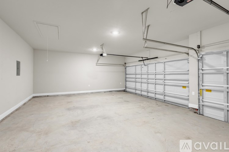 A spacious garage with a white wall and a closed white garage door.