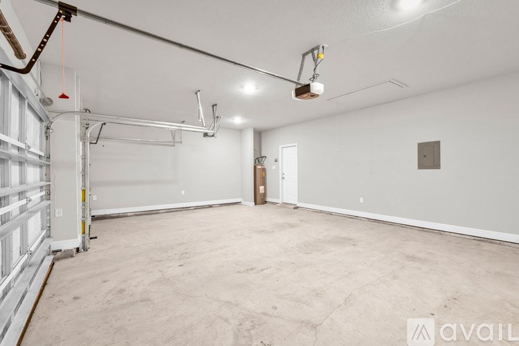 A spacious garage with a door and a wall-mounted light fixture.